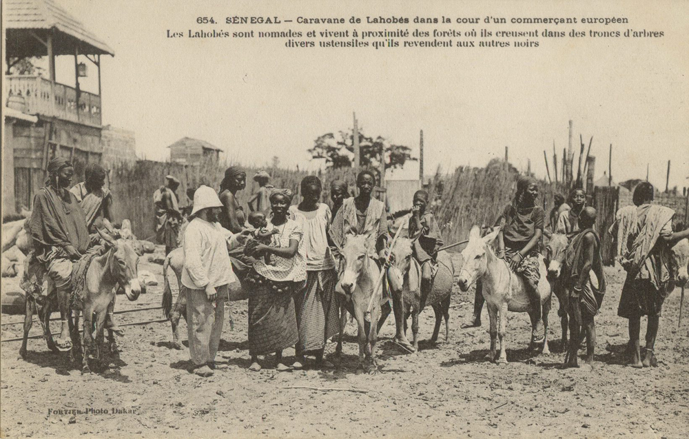 SÉNÉGAL – Caravane de Lahobés dans la cour d’un commerçant européen. Les Lahobés sont nomades et vivent à proximité des forêts o’u ils creusent dans des troncs d’arbres divers utensiles qu’ils revendent aux autres noirs.