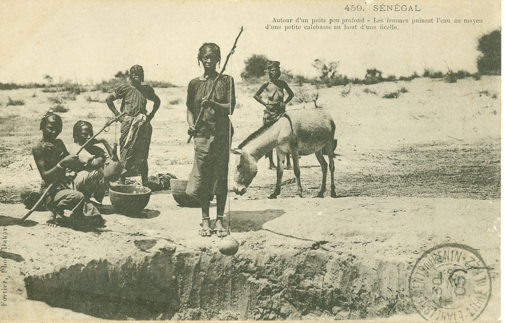 SÉNÉGAL – Autour d’un puits peu profond – Les femmes puisent l’eau au moyen d’une petite calebasse au bout d’une ficelle